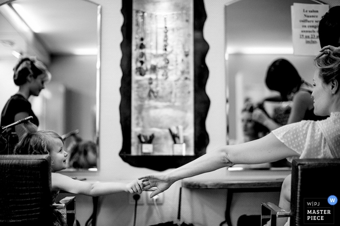 Black and white tribute moment of bride and flower girl getting their hair done together in Paris before the wedding