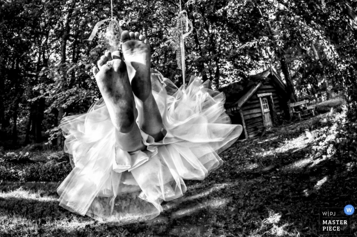 An outdoor black and white photo of the bride's feet as she swings into marriage in Zuid Holland.