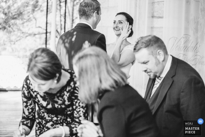 Foto por: <a href="https://www.wpja.com/contests/2014-q3-photography-contest/ceremony/1464921"> Dean Dampney - Australia </a> Nueva Gales del Sur Fotoperiodismo de bodas | La imagen contiene: blanco y negro, novia, novio, recepción, invitados a la boda, anillo