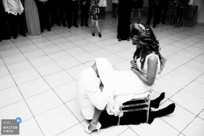 Puerto Rican wedding photographer caught the action of the groom removing the brides garter in this black and white image