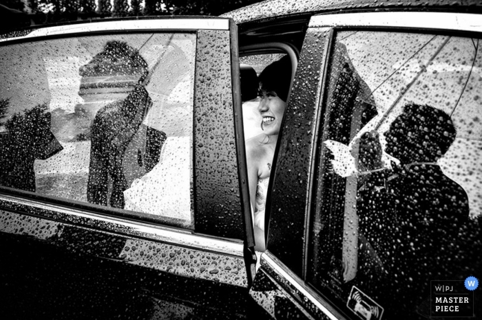 Photo by: <a href="https://www.wpja.com/contests/2014-q4-photography-contest/weather/1535901">Adeline Leonti - Canada</a> Montreal wedding photographer captured this black and white image of a bride sitting in a rain covered car getting ready to walk into the ceremony