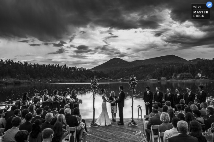Photo by: <a href="https://www.wpja.com/contests/2014-q4-photography-contest/weather/1538736">Preston Utley - United States</a> Vail wedding photographer created this black and white image of the wedding ceremony that is taking place on a lake with mountains in the background