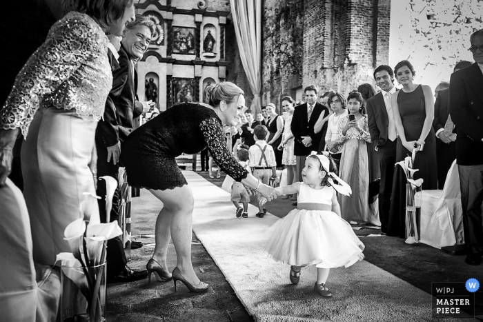 Photo by: <a href="https://www.wpja.com/contests/2015-q1-photography-contest/ceremony/1609471">Fabrizio Proietto - Mexico</a> Playa del Carmen wedding photographer captured this black and white image of a rogue flower girl getting assistance in walking down the aisle