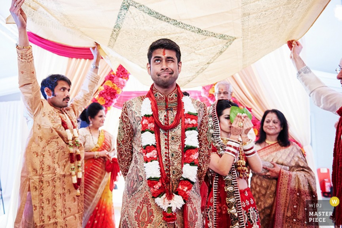Leicestershire wedding photographer captured this photo of a smiling groom as he is surrounded by family