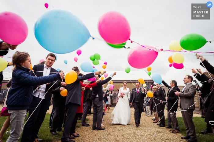 Photo by: <a href="https://www.wpja.com/contests/2015-q3-photography-contest/weather/1669821">Benjamin Brette - France</a> France guests fly balloons towards the bride and groom after the ceremony - France wedding photography