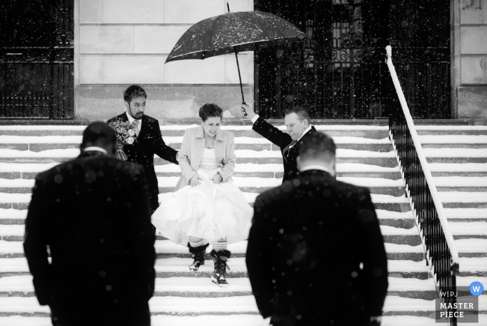 Photo by: <a href="https://www.wpja.com/contests/2015-q3-photography-contest/weather/1696641">Kate McElwee - United States</a> Boston groomsmen holds an umbrella for the bride after the wedding - Massachusetts wedding photo