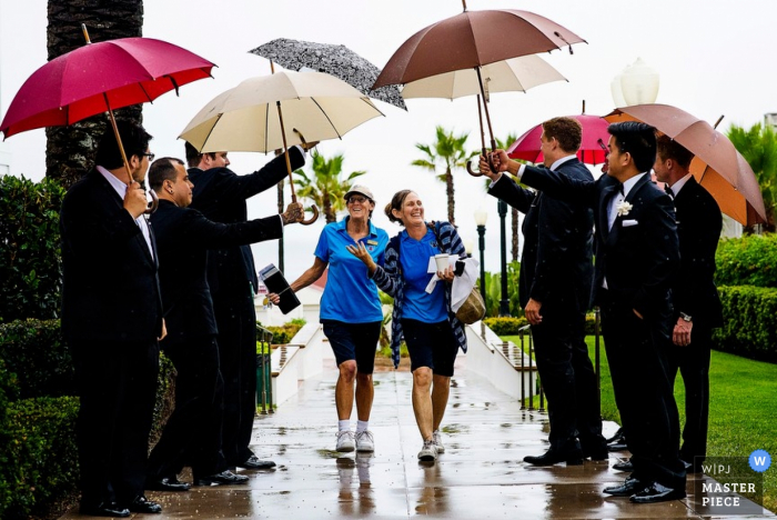 Photo by: <a href="https://www.wpja.com/contests/2015-q3-photography-contest/weather/1701591">Ben Chrisman - United States</a> Charleston groomsmen hold umbrellas for the guests at the wedding - South Carolina wedding photo