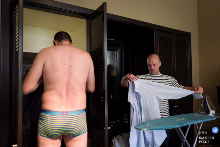 Amsterdam groom getting help getting his clothes ready for the wedding -  Noord Holland wedding photo