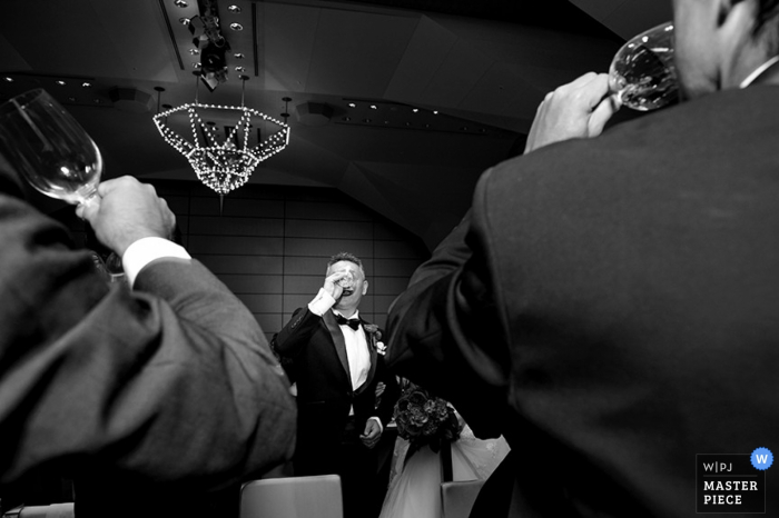 Le photographe de mariage à Tokyo a capturé cette photo en noir et blanc des invités au mariage en sirotant du champagne à la réception