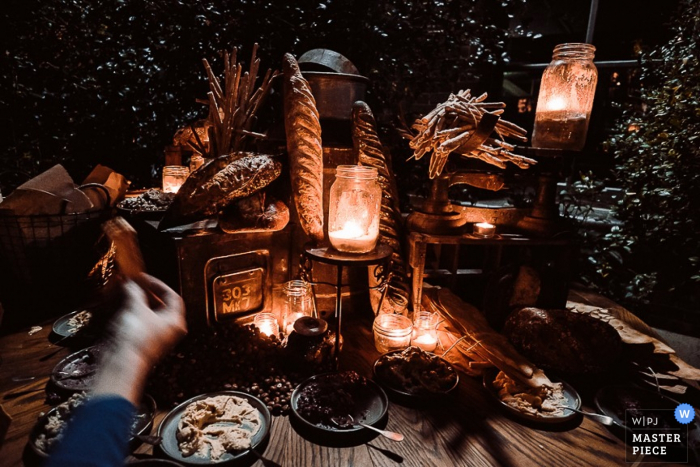 Foto por: <a href="https://www.wpja.com/contests/2015-q3-photography-contest/taste/1667846"> Dean Dampney - Australia </a> El fotógrafo de bodas de Nueva Gales del Sur capturó el suave resplandor de las linternas de tarro de albañil mientras encendían la mesa de aperitivos en esta recepción nocturna al aire libre