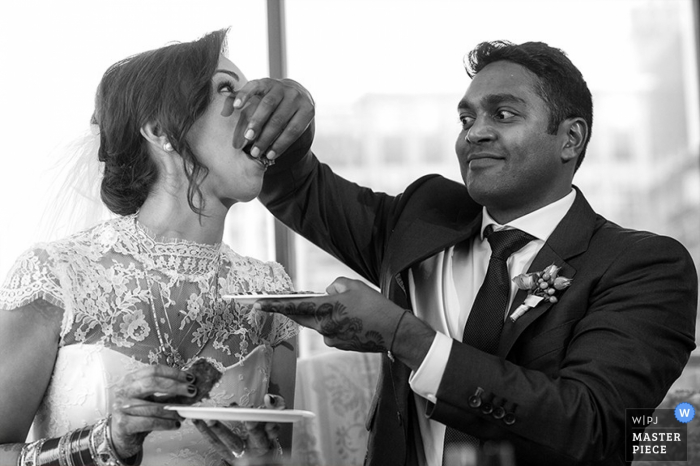 Chicago, la novia y el novio alimentándose mutuamente pastel en la recepción en una foto de boda en blanco y negro de Illinois La novia y el novio de Chicago se dan de comer pastel en la recepción - foto de la boda de Illinois