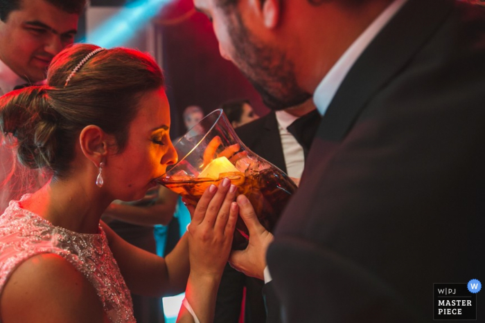 Santa Catarina bride taking a big drink at the reception - Brazil wedding photography