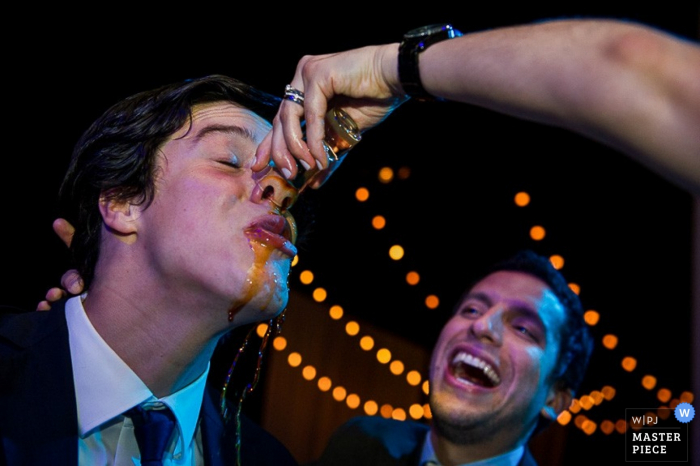 Lima groom spilling some of his drink at the reception - Peru wedding photojournalism