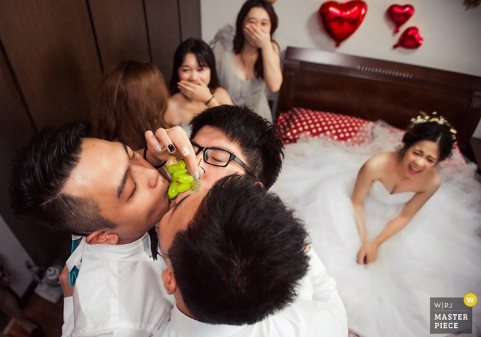 Jianxi groom and groomsmen sharing food while bride laughs - China wedding photography