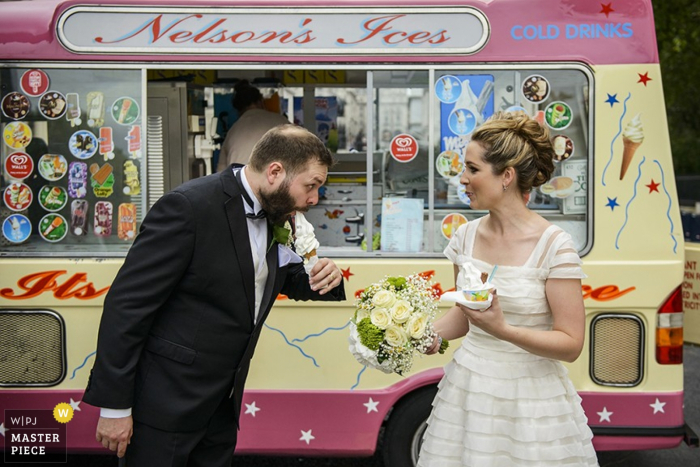 La novia y el novio de Londres comen helado después de la boda - Foto de reportaje de boda de Inglaterra con un camión de helados La novia y el novio de Londres comen helado después de la boda - Foto de reportaje de boda de Inglaterra con un camión de helados