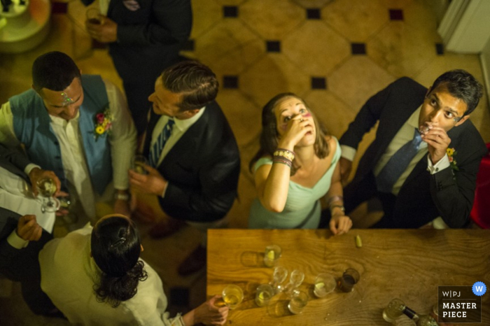 Convidados de Londres desfrutando de bebidas e shots no bar da recepção - fotografia de casamento na Inglaterra