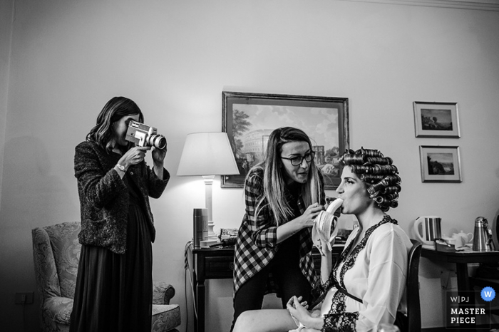 Novia de Roma comiendo mientras se arregla el cabello antes de la boda en Lazio La novia de Roma come mientras se prepara el cabello antes de la boda: fotoperiodismo de bodas en Lazio