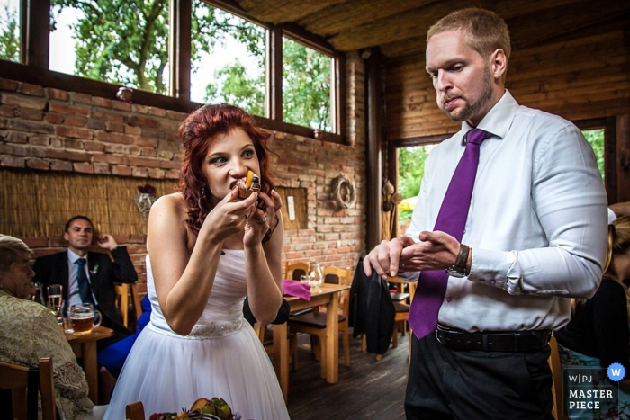 Praagse bruid en bruidegom eten taart bij de receptie - Tsjechische trouwfoto