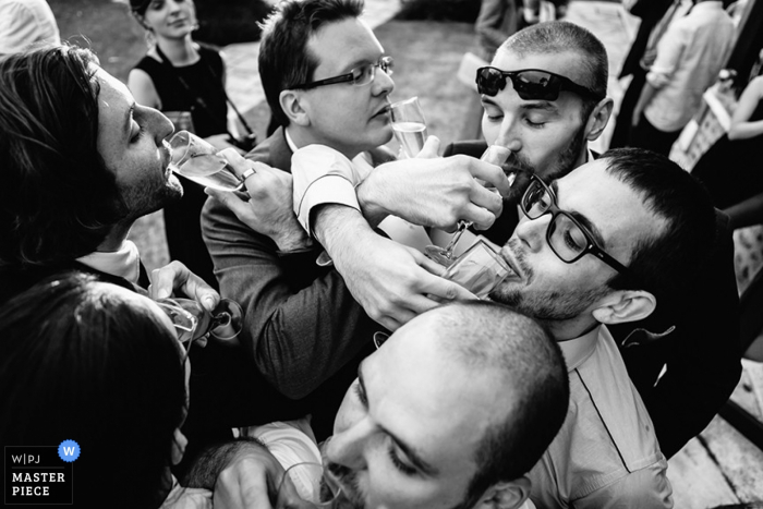 Photo by: <a href="https://www.wpja.com/contests/2015-q4-photography-contest/toastingspeeches/1708011">Jeremy Fiori - France</a> Pays de la Loire guests cross arms with their drinks at the reception | France wedding photo