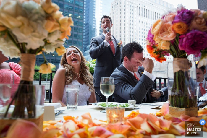 Photo by: <a href="https://www.wpja.com/contests/2015-q4-photography-contest/toastingspeeches/1731696">John Zich - United States</a> Chicago bride and groom laugh as best man does his speech at the reception | Illinois wedding photography