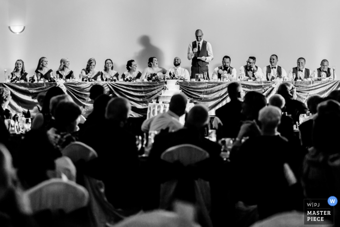 Photo by: <a href="https://www.wpja.com/contests/2015-q4-photography-contest/toastingspeeches/1748821">Dan Salvo - United States</a> Delaware wedding reception photograph of a speech in black and white