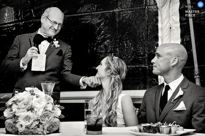 Photo by: <a href="https://www.wpja.com/contests/2015-q4-photography-contest/toastingspeeches/1764306">Julie Ambos - United States</a> Key West wedding reception photo during speech by father | FL wedding photographer