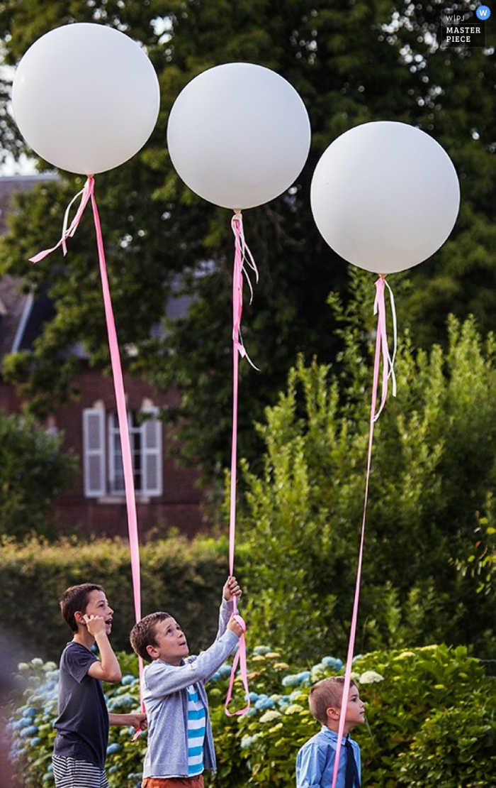 Photo by: <a href="https://www.wpja.com/contests/2015-q4-photography-contest/symmetry/1705846">Philip Stephenson - France</a> Paris kids hold balloons for the wedding | France wedding photojournalism