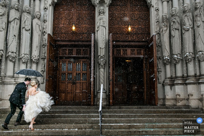 Foto von: <a href="https://www.wpja.com/contests/2015-q4-photography-contest/symmetry/1727971"> Steven Young - Vereinigte Staaten </a> Manhattan braut und bräutigam zu fuß die kirchentreppe hinauf mit einem regenschirm New York City Hochzeitsfotografie