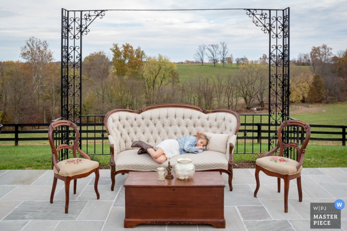 Photo by: <a href="https://www.wpja.com/contests/2015-q4-photography-contest/symmetry/1744261">Abram Eric Landes - United States</a> Little girl in Washington DC gets tired on the couch at the wedding | District of Columbia photo