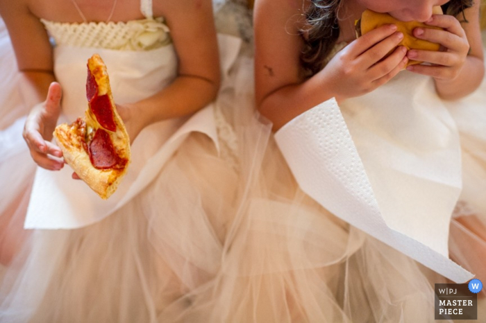 Photographie de réception de mariage de la Nouvelle-Écosse montrant des filles de fleurs mangeant une pizza