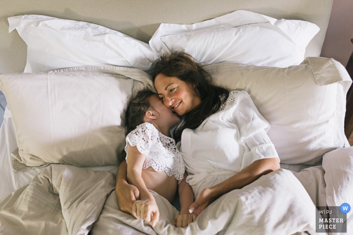 Foto di: <a href="https://www.wpja.com/contests/2015-q4-photography-contest/bride-getting-ready/1717571"> Marine Poron - Francia </a> La sposa di Parigi giace con un bambino piccolo nel suo vestito | Fotografia di matrimonio in Francia