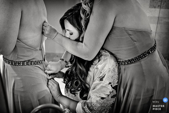 Foto di: <a href="https://www.wpja.com/contests/2015-q4-photography-contest/bride-getting-ready/1764001"> Julie Ambos - Stati Uniti </a> Fotografia di matrimonio in Florida di preparare le donne facendo schiene di vestiti