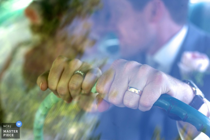 Photo by: <a href="https://www.wpja.com/contests/2015-q4-photography-contest/ring-details/1722786">Kathi Robertson - Canada</a> Ottawa bride and groom put hands on sterling wheel showing their wedding rings | Ontario wedding photography