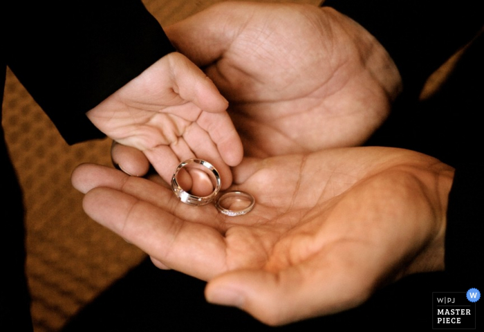 Photo by: <a href="https://www.wpja.com/contests/2015-q4-photography-contest/ring-details/1722881">Mike Lupine - Canada</a> Ottawa little child puts wedding rings into someones hand | Ontario wedding photojournalism