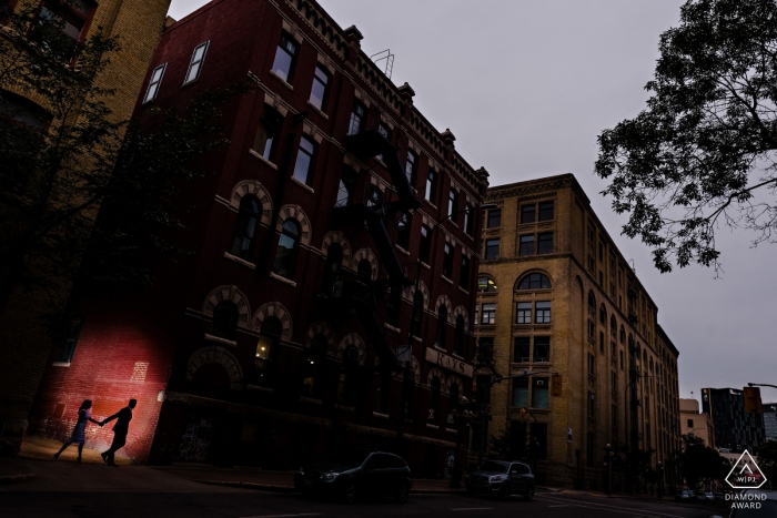 Winnipeg Engagement Photo. Hand in hand, this couple walks in the city. Silhouette pre-wedding portraits.