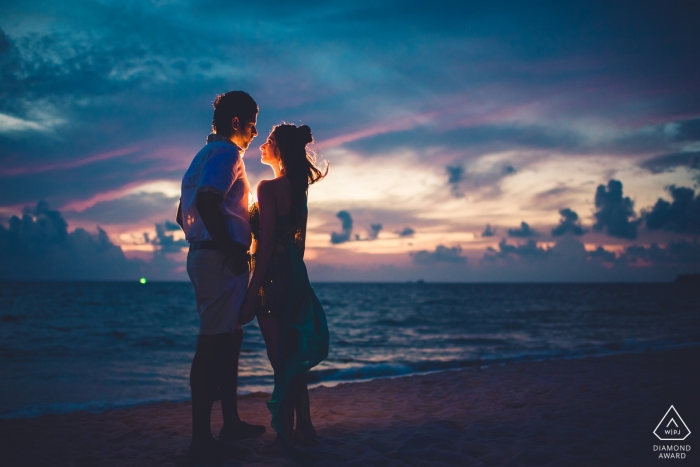 India Engagement Photo. Na plaży w pobliżu zachodu słońca z jednym świecącym światłem na tej parze.