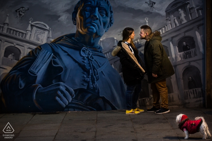Photo by: <a href="https://www.wpja.com/photos/diamond-award-top-wedding-engagement-photographer/2170431">Miguel Onieva - Madrid Madrid Spain Engagement Photographer. Street art wall mural portrait with a small dog in a red jacket.