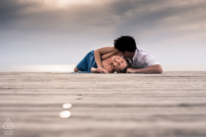 Landes Couple lying on boardwalk in Nouvelle-Aquitaine for their Engagement Photos