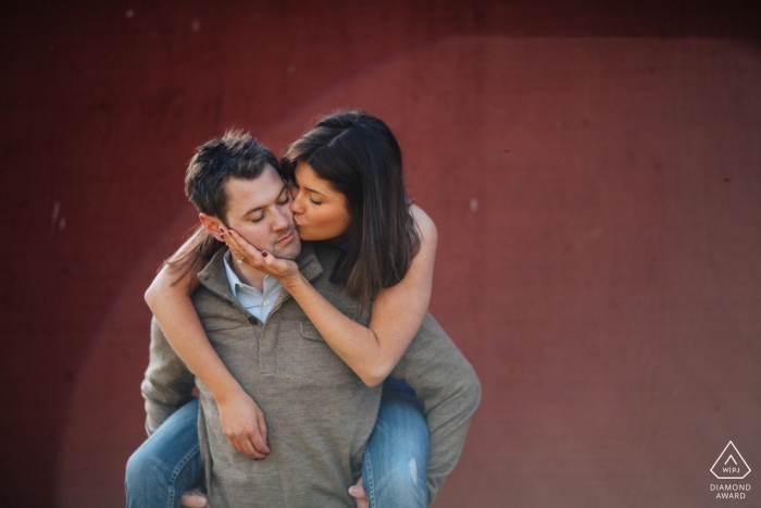 WA engagement pre wedding piggy back session against a red wall WA engagement shoot | pre wedding piggy back session