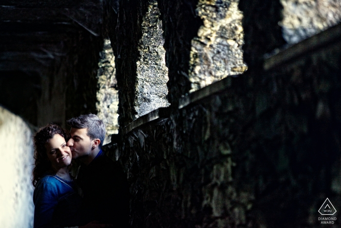 Stone arches create dramatic lighting for this Lombardi engagement portrait