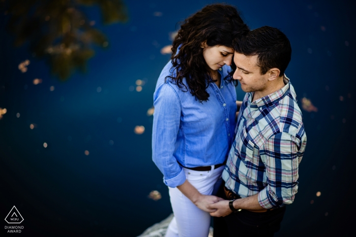 Engagement portrait shots from a high angle of this couple next to the water In Burlington Vermont