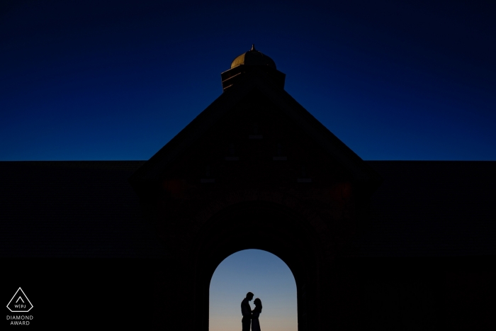 Stark et audacieux, ce couple du Vermont est encadré et se profilant dans un Archway pour leur portrait de fiançailles