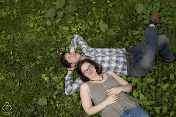 Casual relaxing afternoon portrait shot from above in the park for this engaged couple Casual relaxing afternoon portrait shot from above in the park for this engaged couple
