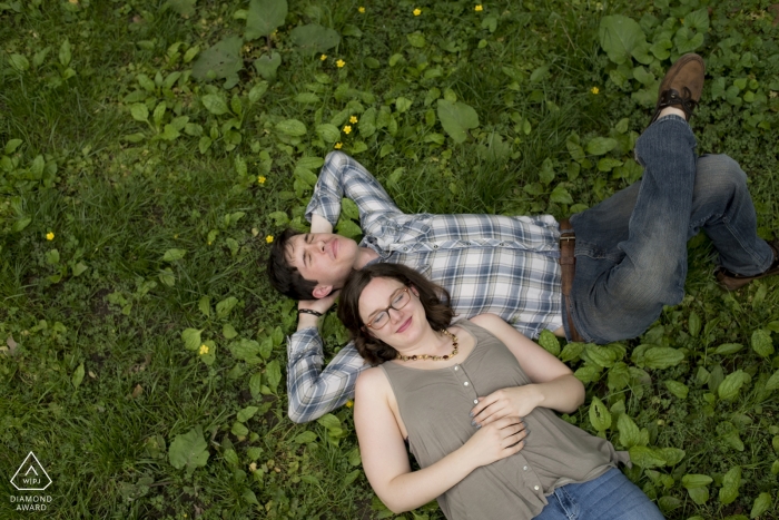 Casual relaxing afternoon portrait shot from above in the park for this engaged couple