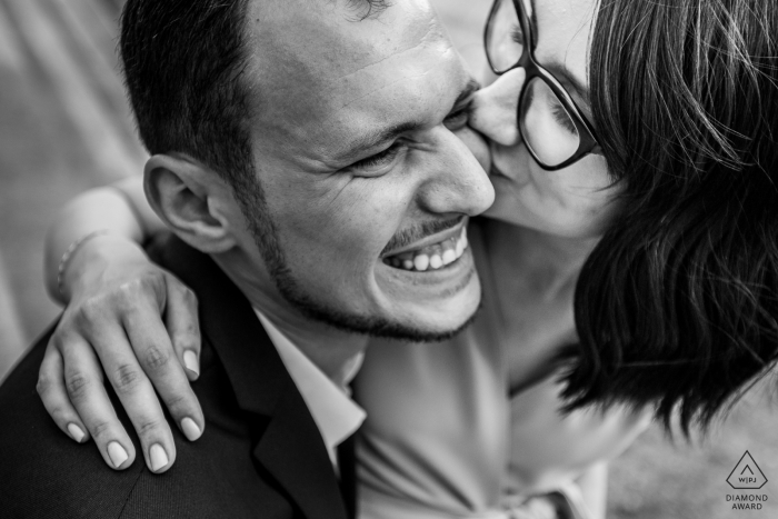 Bucharest couple tightly framed in a black-and-white portrait with a kiss on the cheek