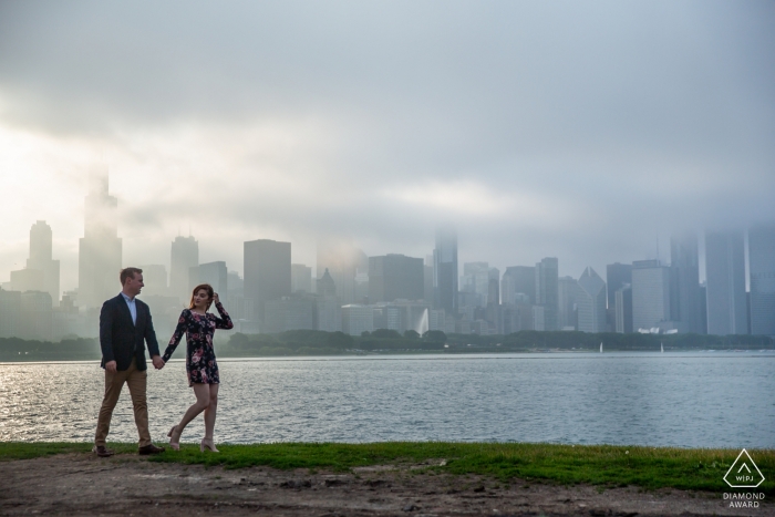 Photo by: <a href="https://www.wpja.com/photos/diamond-award-top-wedding-engagement-photographer/2233411">Victoria Sprung - United States Wedding Photographer</a> A walk next to the river in the afternoon sun along with the city's skyline behind make for a wonderful engagement portrait in Chicago.
