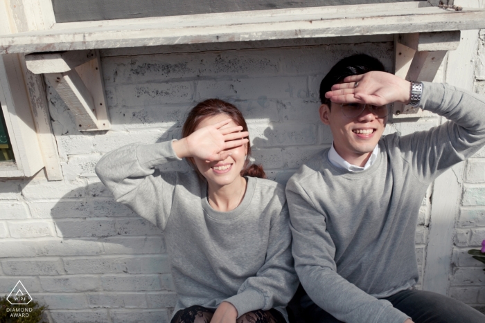 Photo by: <a href="https://www.wpja.com/photos/diamond-award-top-wedding-engagement-photographer/2237691">Chin Whei Tay - Malaysia Wedding Photographer</a> Shading the sun from their eyes with their hands this Malaysia couple poses During their pre-wedding portrait session