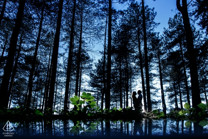 Photo by: <a href="https://www.wpja.com/photos/diamond-award-top-wedding-engagement-photographer/2227056">Toni Darcy - United Kingdom Wedding Photographer</a> Silhouette of couple hugging in the forest with deep blue skies in the background | England Photographer
