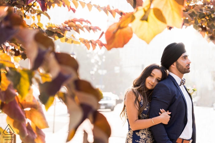 Photographie de fiançailles en Californie d'un couple avec des feuilles d'automne