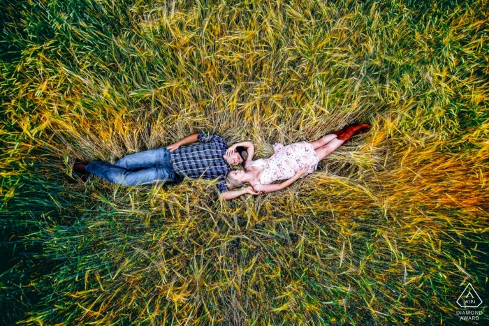Alberta Engagement Foto's van een paar dat in hoog gras ligt en van een drone is geschoten